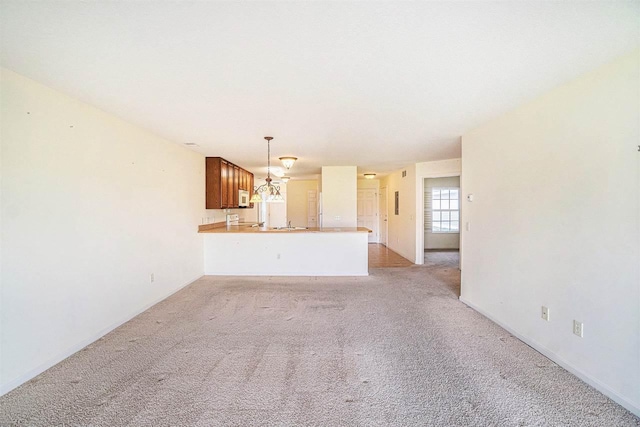 1556 Emerald Ct Unit 89, Petoskey, MI 49770 - unfurnished living room featuring light colored carpet and a chandelier