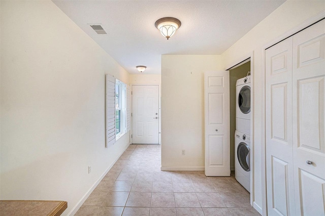 1556 Emerald Ct Unit 89, Petoskey, MI 49770 - washroom with stacked washer / dryer, baseboards, and light tile patterned floors