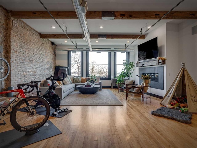 422 E Mitchell Unit 1, Petoskey, MI 49770 - living area with beam ceiling, hardwood / wood-style flooring, brick wall, and a tiled fireplace