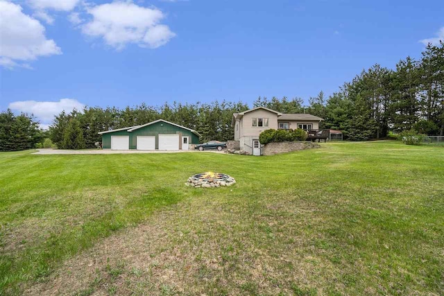 4024 Behling, Boyne City, MI 49712 - view of grassy yard featuring a detached garage, an outdoor fire pit, and an outbuilding