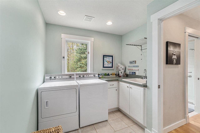 9030 Sugar Tree Ln, Charlevoix, MI 49720 - laundry area with washer and clothes dryer, cabinet space, baseboards, and a textured ceiling