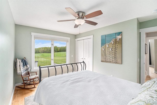 9030 Sugar Tree Ln, Charlevoix, MI 49720 - bedroom featuring a closet, wood finished floors, a ceiling fan, and baseboards