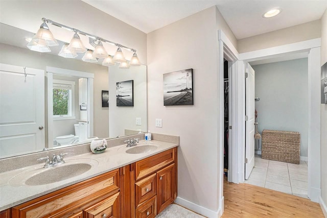9030 Sugar Tree Ln, Charlevoix, MI 49720 - bathroom with toilet, double vanity, baseboards, and wood finished floors