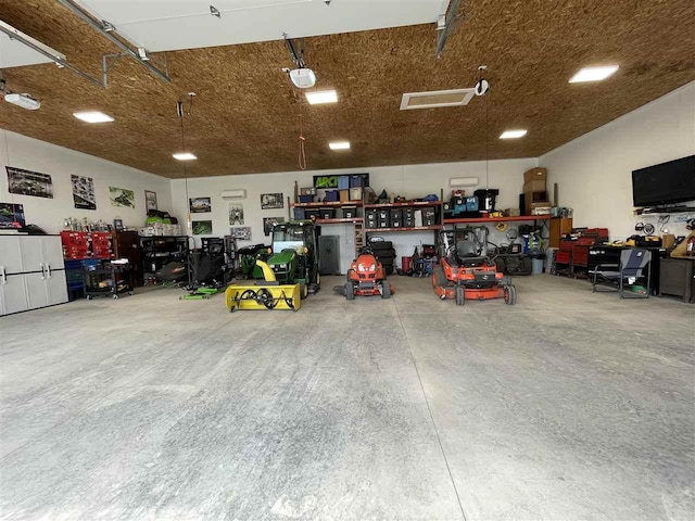 9030 Sugar Tree Ln, Charlevoix, MI 49720 - garage with a workshop area and a garage door opener