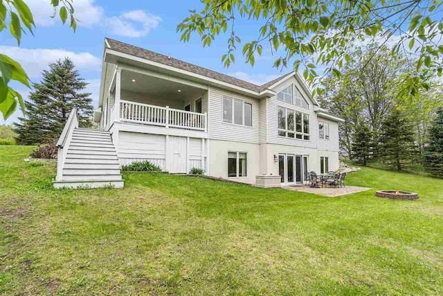 9030 Sugar Tree Ln, Charlevoix, MI 49720 - rear view of house with stairs, a fire pit, a yard, a patio area, and stucco siding