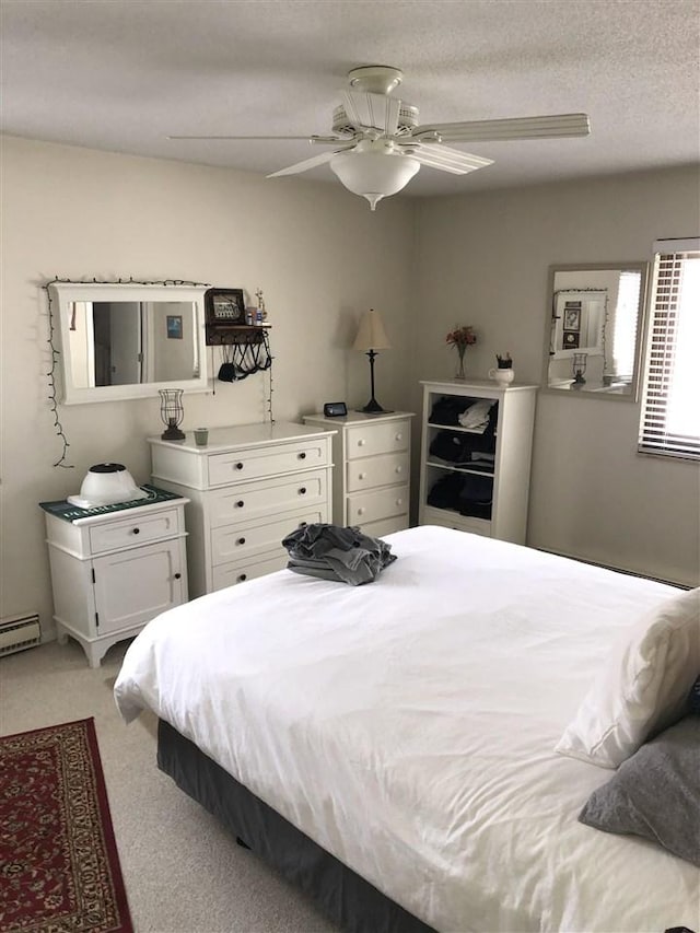 915 Robinson St Unit 2, Boyne City, MI 49712 - bedroom with light carpet, a ceiling fan, and a baseboard heating unit