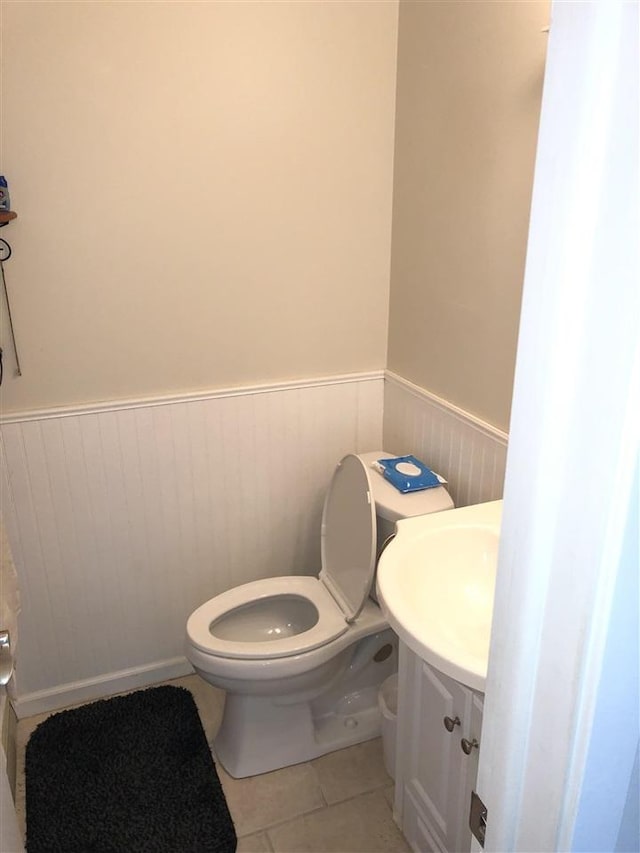 915 Robinson St Unit 2, Boyne City, MI 49712 - bathroom featuring a wainscoted wall, toilet, tile patterned floors, and a sink
