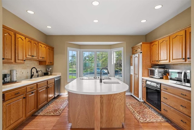 8530 Dustin Ln, East Jordan, MI 49727 - kitchen with appliances with stainless steel finishes, a sink, an island with sink, recessed lighting, and light countertops