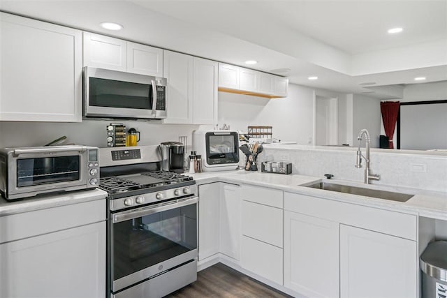 8530 Dustin Ln, East Jordan, MI 49727 - kitchen with appliances with stainless steel finishes, a sink, recessed lighting, white cabinets, and dark wood-style floors