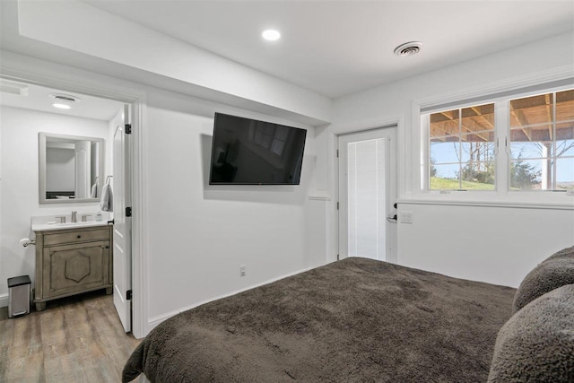 8530 Dustin Ln, East Jordan, MI 49727 - bedroom with light wood-style flooring and ensuite bath