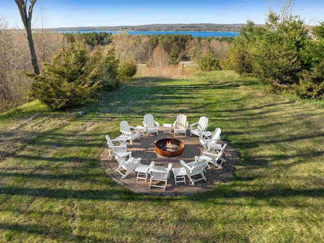 8530 Dustin Ln, East Jordan, MI 49727 - view of grassy yard with an outdoor fire pit and a water view