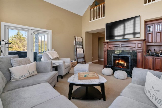 8530 Dustin Ln, East Jordan, MI 49727 - living room with high vaulted ceiling, a premium fireplace, light carpet, and baseboards