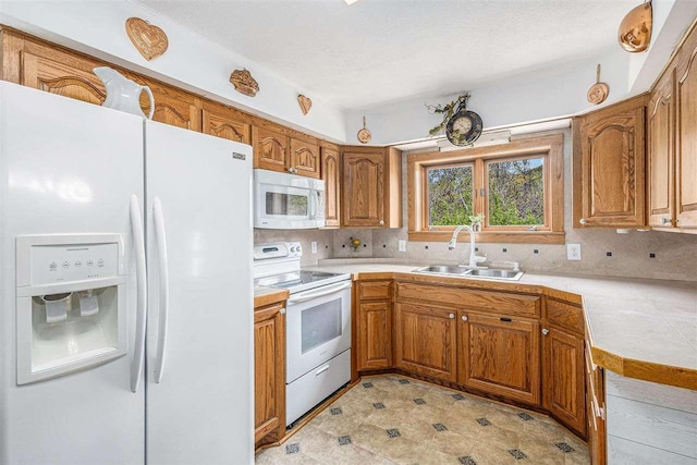 6073 Rocky Beach Ave, Charlevoix, MI 49720 - kitchen featuring white appliances, a sink, brown cabinetry, and decorative backsplash