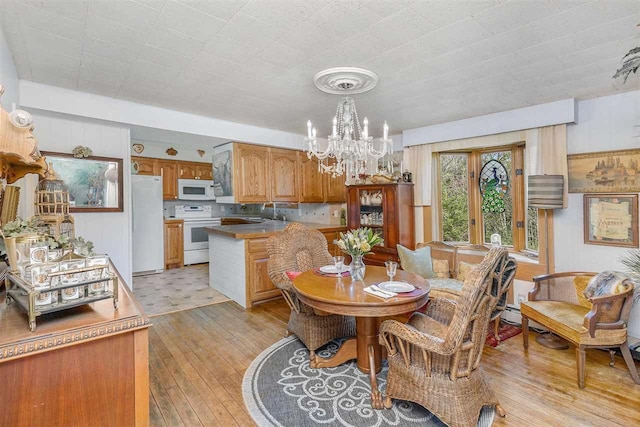 6073 Rocky Beach Ave, Charlevoix, MI 49720 - dining area with a chandelier and light wood-style flooring