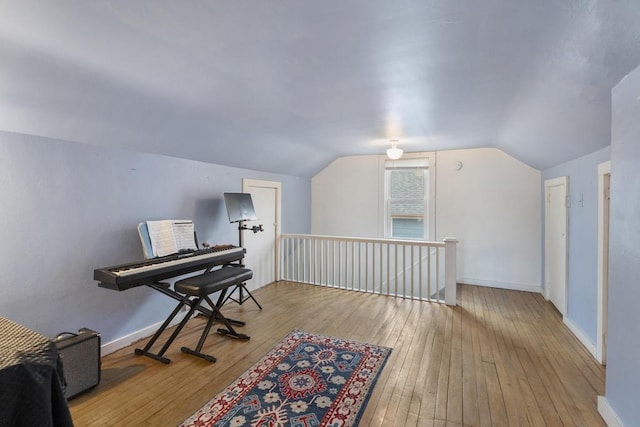 1117 E Mitchell St, Petoskey, MI 49770 - sitting room with an upstairs landing, wood-type flooring, vaulted ceiling, and baseboards
