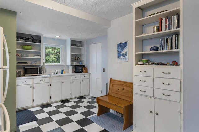 1117 E Mitchell St, Petoskey, MI 49770 - kitchen featuring open shelves, stainless steel microwave, light floors, a textured ceiling, and white cabinetry