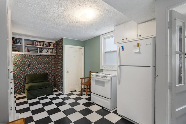 1117 E Mitchell St, Petoskey, MI 49770 - kitchen featuring white appliances, light flooring, white cabinets, and a textured ceiling