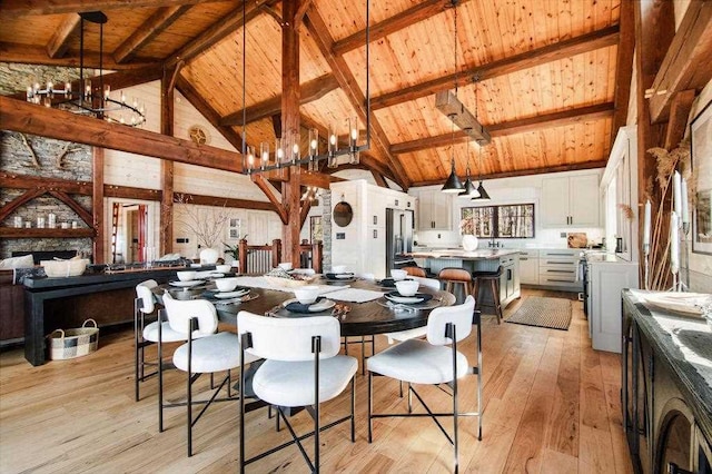 2149 Old Horton Bay Rd, Boyne City, MI 49712 - dining room with a chandelier, wood ceiling with exposed beams, high vaulted ceiling, and light wood finished floors