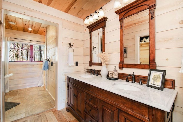 2149 Old Horton Bay Rd, Boyne City, MI 49712 - bathroom with wooden walls, double vanity, wood ceiling, and wood finished floors
