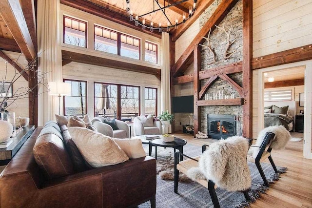 2149 Old Horton Bay Rd, Boyne City, MI 49712 - living room with high vaulted ceiling, wood finished floors, a stone fireplace, a chandelier, and wood ceiling with exposed beams