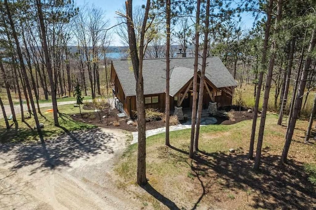 2149 Old Horton Bay Rd, Boyne City, MI 49712 - view of front of home featuring a shingled roof, dirt driveway, and a front lawn