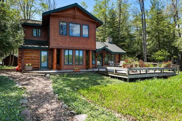 10819 Pioneer Trl, Boyne Falls, MI 49713 - rear view of property with a lawn, a deck, and a chimney