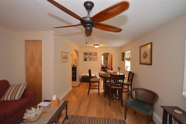 413 E Main St, Boyne City, MI 49712 - dining area with arched walkways, light wood finished floors, ceiling fan, and baseboards