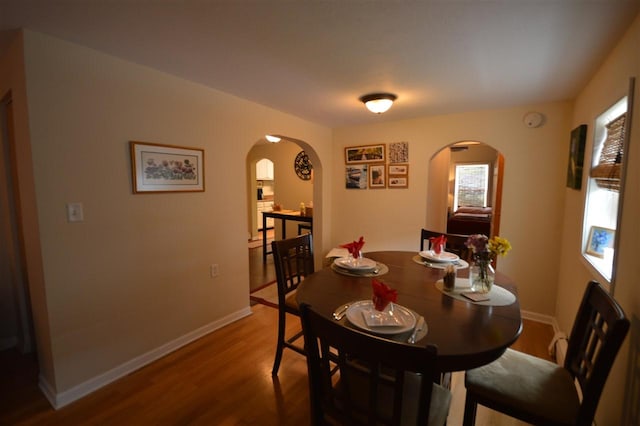 413 E Main St, Boyne City, MI 49712 - dining area featuring arched walkways, wood finished floors, and baseboards