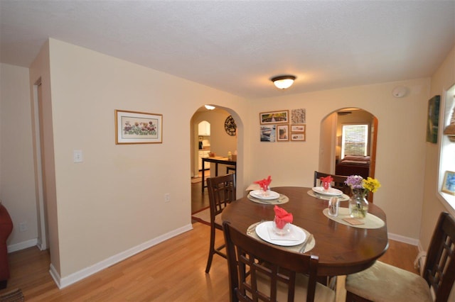 413 E Main St, Boyne City, MI 49712 - dining space with arched walkways, light wood-style floors, and baseboards