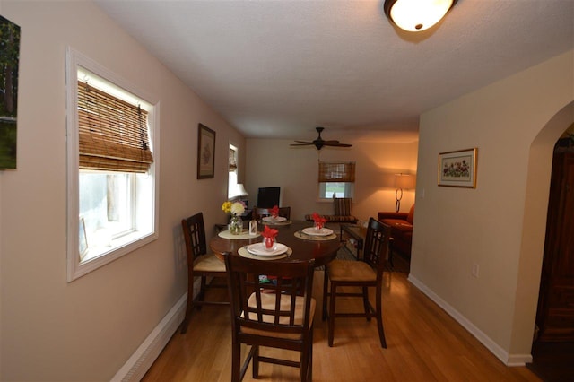 413 E Main St, Boyne City, MI 49712 - dining space with arched walkways, light wood-type flooring, plenty of natural light, and a ceiling fan