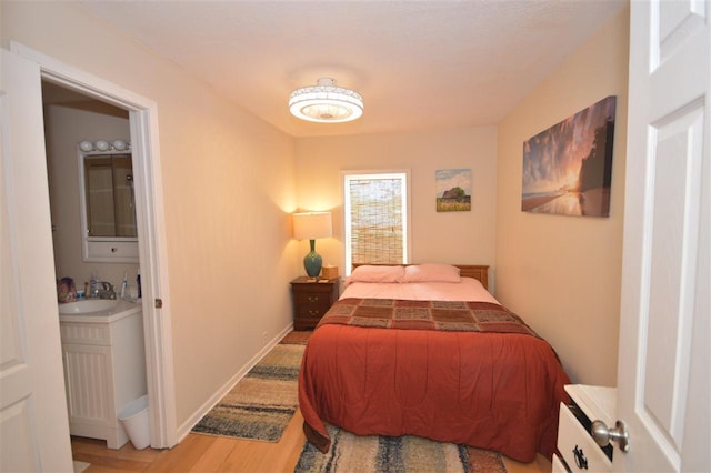 413 E Main St, Boyne City, MI 49712 - bedroom with wood finished floors, a sink, and connected bathroom