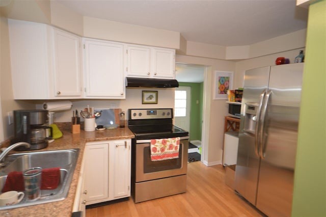413 E Main St, Boyne City, MI 49712 - kitchen featuring stainless steel appliances, under cabinet range hood, a sink, and white cabinets