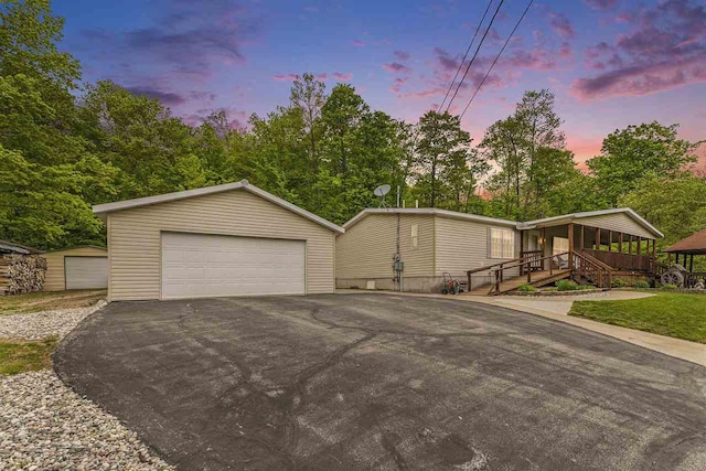 8370 Sisson, Bellaire, MI 49615 - view of front facade with a detached garage, an outdoor structure, and view of scattered trees