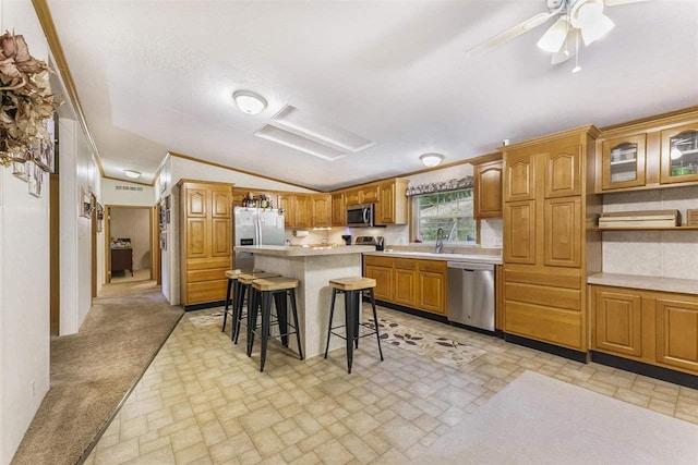 8370 Sisson, Bellaire, MI 49615 - kitchen with appliances with stainless steel finishes, lofted ceiling, a kitchen breakfast bar, light countertops, and brick patterned floors