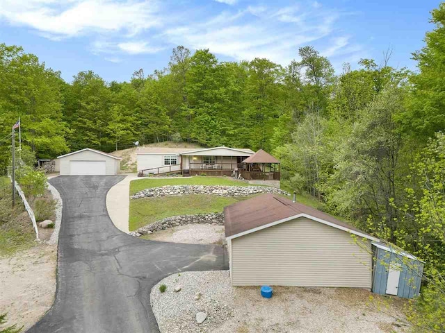 8370 Sisson, Bellaire, MI 49615 - view of front of home featuring an outbuilding, a detached garage, a view of trees, and a front lawn