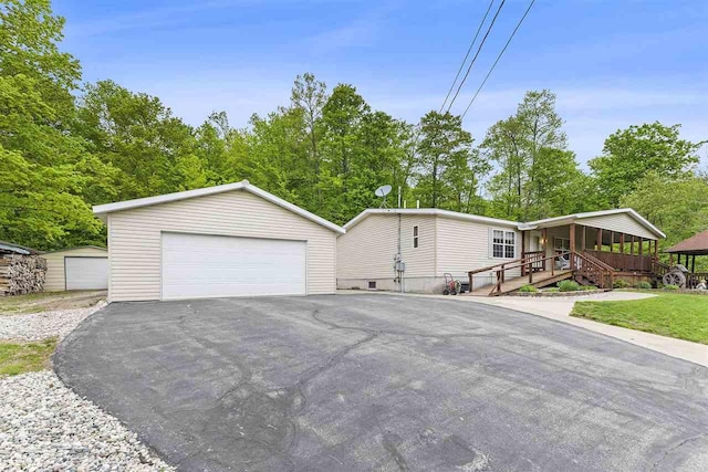 8370 Sisson, Bellaire, MI 49615 - view of front facade featuring an outdoor structure, a detached garage, and covered porch