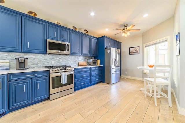 6040 Pine Lake Club Dr Unit 24, Charlevoix, MI 49720 - kitchen featuring appliances with stainless steel finishes, blue cabinetry, light countertops, and recessed lighting