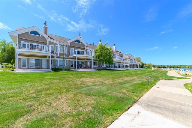 6040 Pine Lake Club Dr Unit 24, Charlevoix, MI 49720 - back of property with a lawn and a chimney