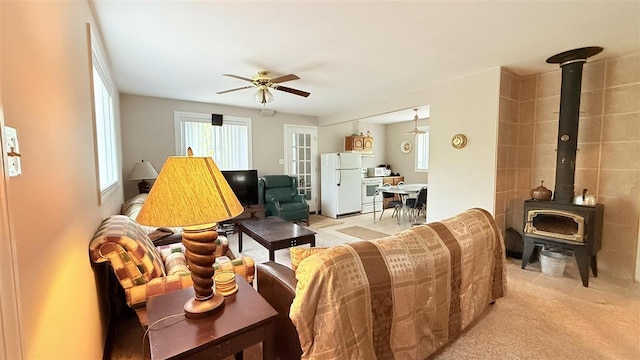 8902 Pickerel Lake Rd, Vanderbilt, MI 49795 - living area with a wood stove, a ceiling fan, and light colored carpet