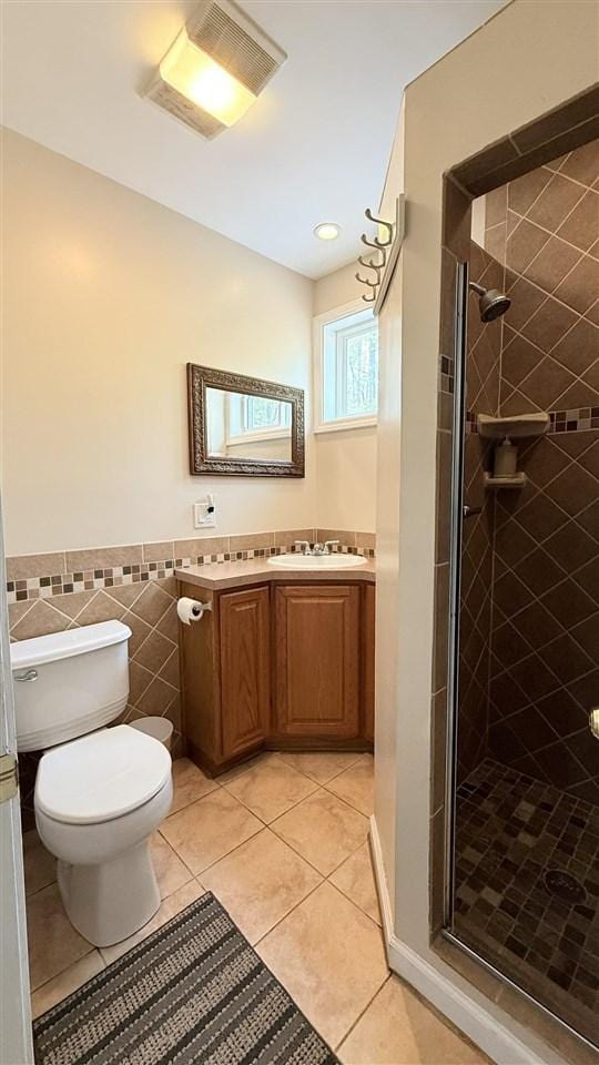 8902 Pickerel Lake Rd, Vanderbilt, MI 49795 - full bath featuring toilet, vanity, a stall shower, tile patterned flooring, and wainscoting