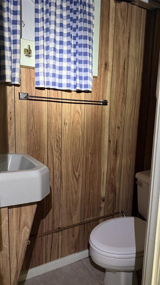 8705 Del Mason Rd, Mancelona, MI 49659 - half bathroom with toilet and wooden walls