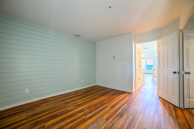 301 Michigan Ave Unit 13, Charlevoix, MI 49720 - empty room featuring dark wood-type flooring, baseboards, and wooden walls
