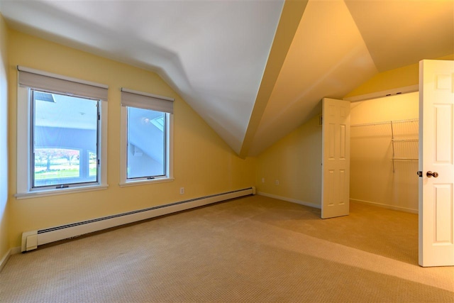 301 Michigan Ave Unit 13, Charlevoix, MI 49720 - additional living space featuring a baseboard heating unit, light carpet, lofted ceiling, and plenty of natural light