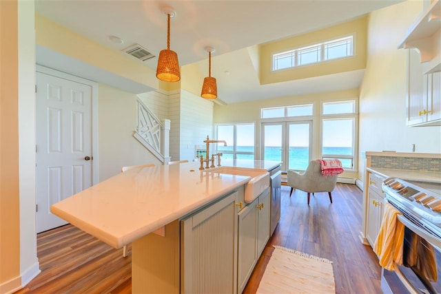 301 Michigan Ave Unit 13, Charlevoix, MI 49720 - kitchen with a sink, dark wood-style floors, appliances with stainless steel finishes, light countertops, and a high ceiling