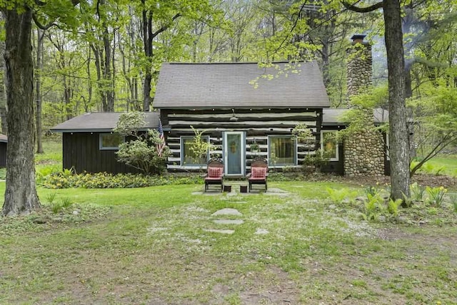 680 N Lake Shore Dr, Harbor Springs, MI 49740 - back of house featuring a chimney and a lawn