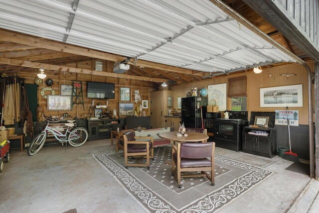 680 N Lake Shore Dr, Harbor Springs, MI 49740 - garage with freestanding refrigerator, wood walls, and a garage door opener