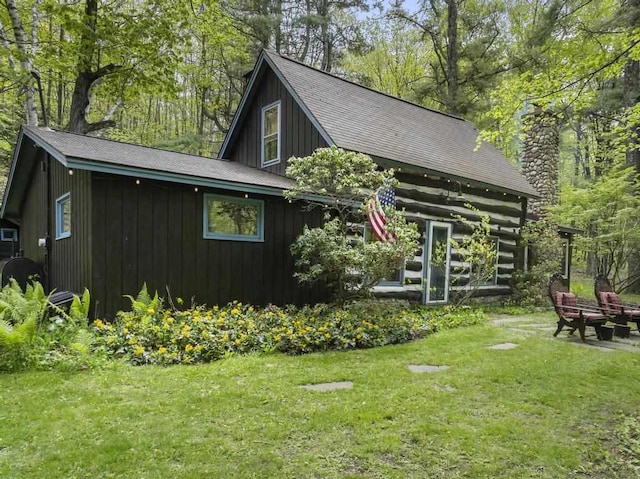 680 N Lake Shore Dr, Harbor Springs, MI 49740 - view of home's exterior featuring a lawn, a chimney, and a shingled roof