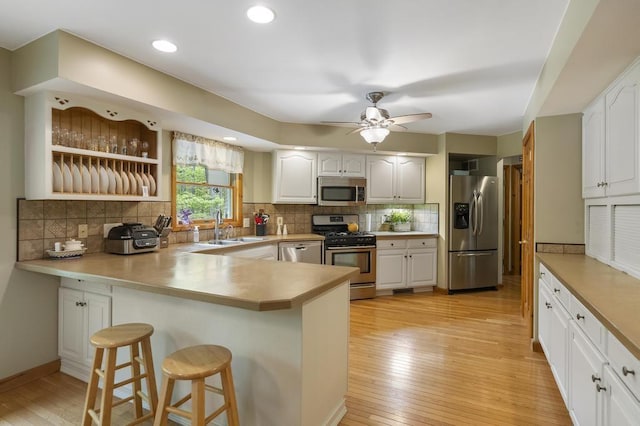4545 Lintlong Rd, Petoskey, MI 49770 - kitchen with stainless steel appliances, a sink, a peninsula, a breakfast bar, and backsplash