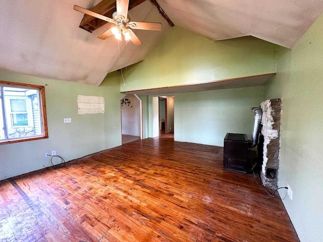 2378 E Old State Rd, East Jordan, MI 49727 - unfurnished room featuring a wood stove, wood finished floors, high vaulted ceiling, and ceiling fan