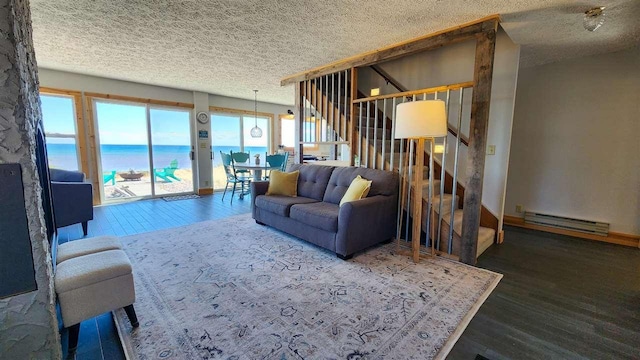 15718 N Blueberry Ln, Paradise, MI 49768 - living area with a baseboard heating unit, wood finished floors, a textured ceiling, and stairs